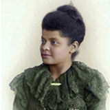Ida B. Wells Hand painted photograph of an attractive African American woman. She is wearing a green dress with ruffles. Her hair is natural and pulled up into a bun.