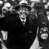 President Woodrow Wilson President Woodrow Wilson holding a baseball in a crowd filled outdoor stadium.